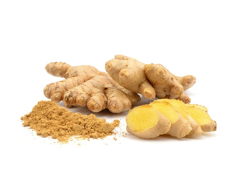 Frische Ingwerknollen liegen neben etwas Ingwerpulver und in Scheiben geschnittenem Ingwer. Die Ingwerwurzeln sind beige und knorrig, während das Pulver eine bräunliche Farbe hat.