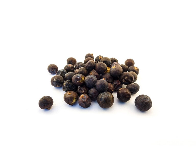 Eine Ansammlung von schwarzen Beeren mit leicht glänzender Oberfläche liegt verstreut auf einem weißen Hintergrund. Die Beeren sind rund und variieren in Größe und Form.